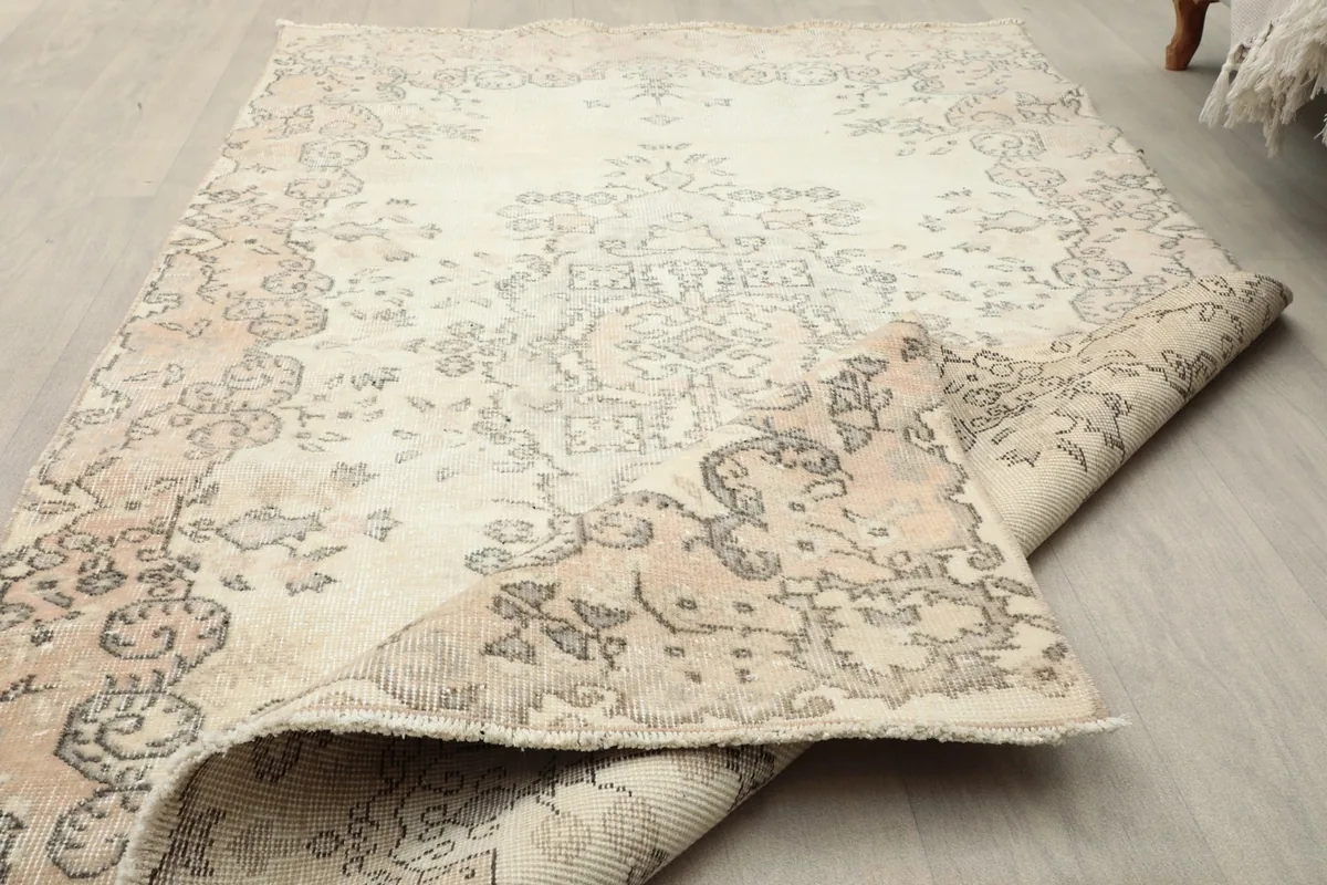 The rug partially rolled back, revealing the reverse side and the visible knots on the cotton foundation.