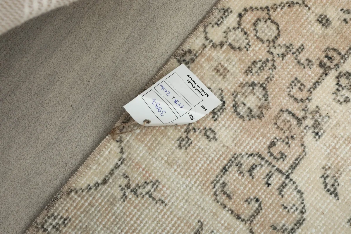 Close-up of the rug's tag, indicating its origin, materials, and unique product information.