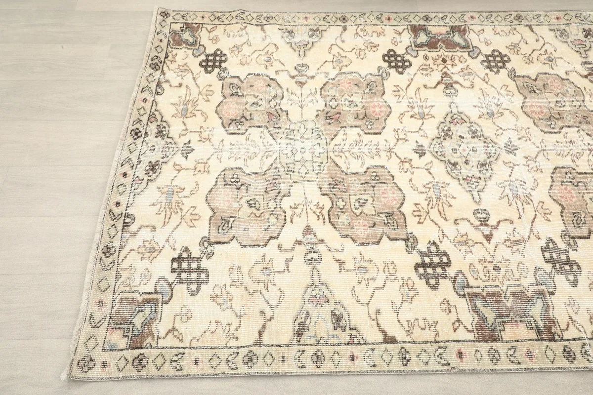 Another angle shot of the vintage rug, showing the faded ivory and brown hues