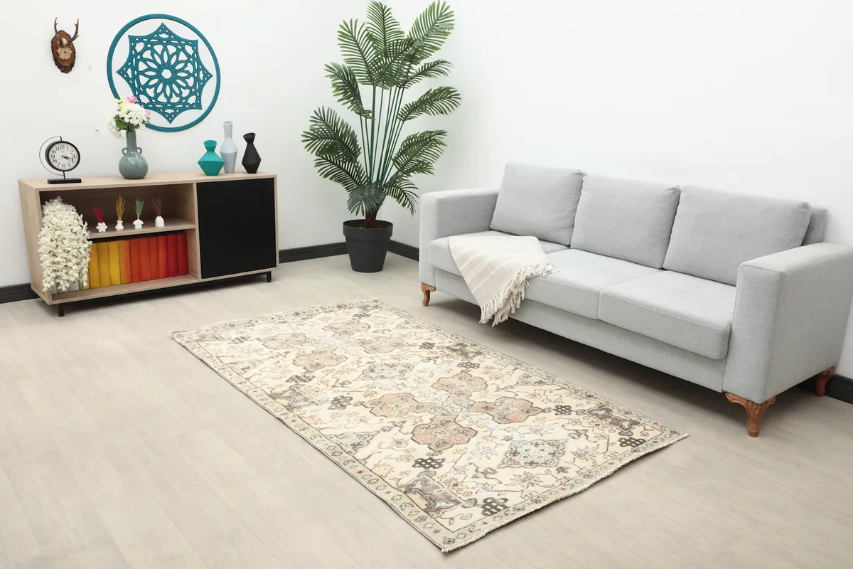 Vintage rug placed in a living room setting with a gray sofa and modern decor