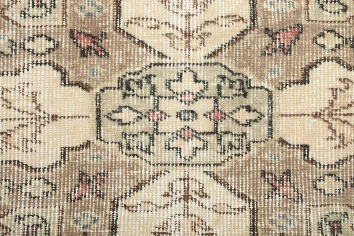 Close-up of the wool pile showing the texture and muted colors of the vintage rug
