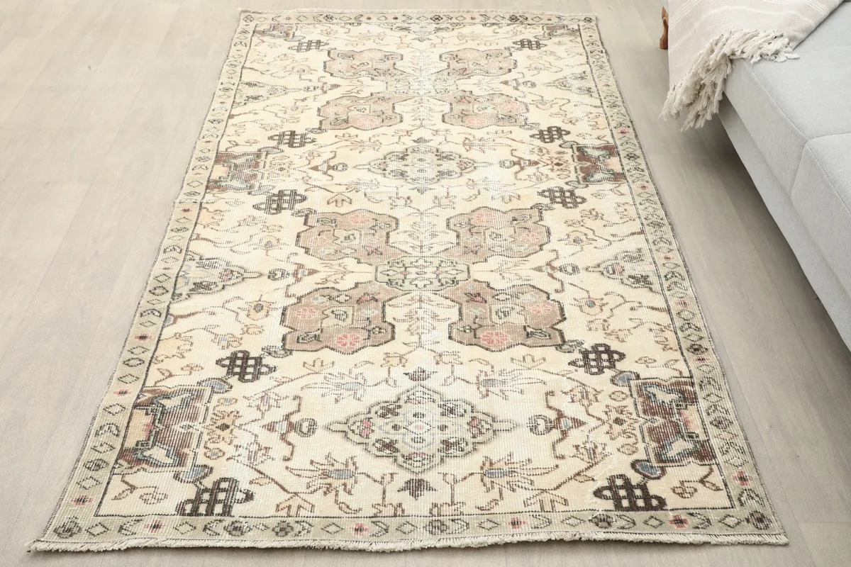 Overhead view of the vintage rug on a light floor, showing its full pattern and colors