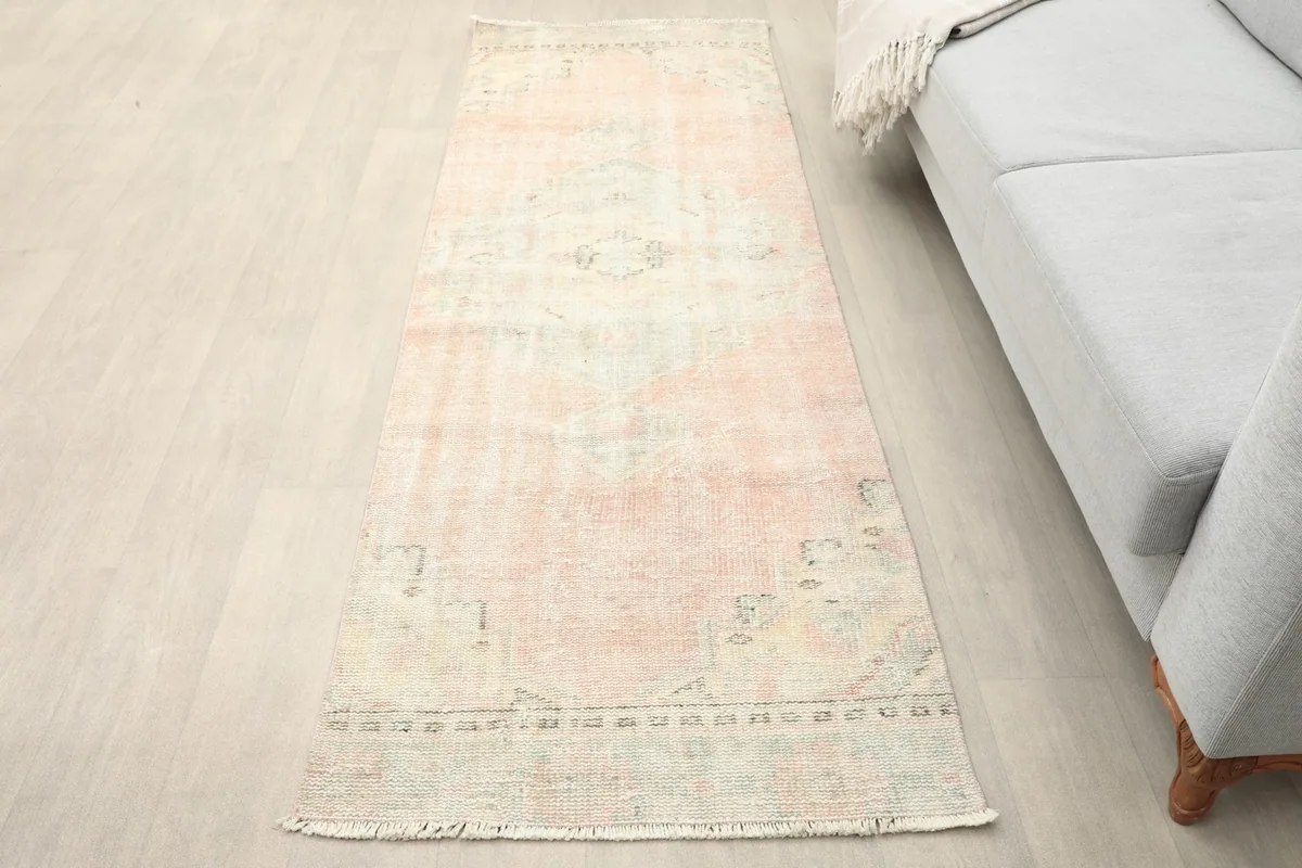 Runner rug placed on a light floor next to a gray sofa, showing its scale in a living area