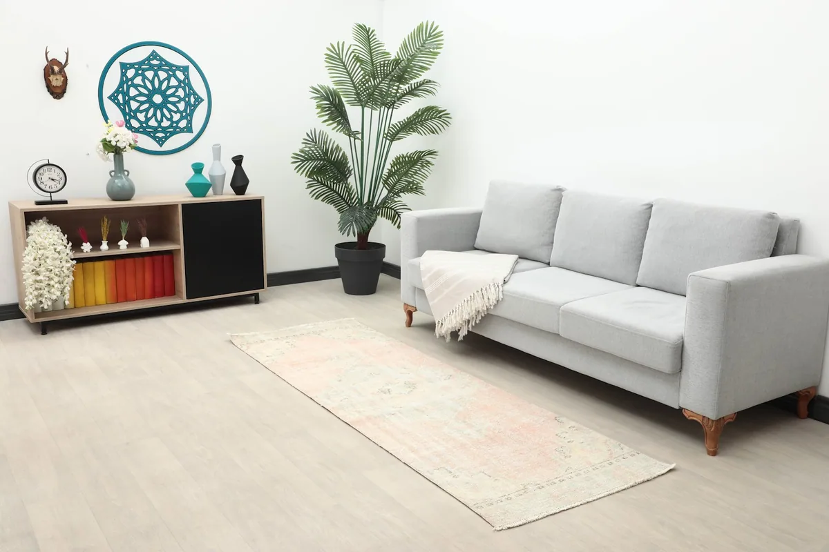 Long shot of the runner in a room with a gray sofa and a small cabinet, highlighting its length