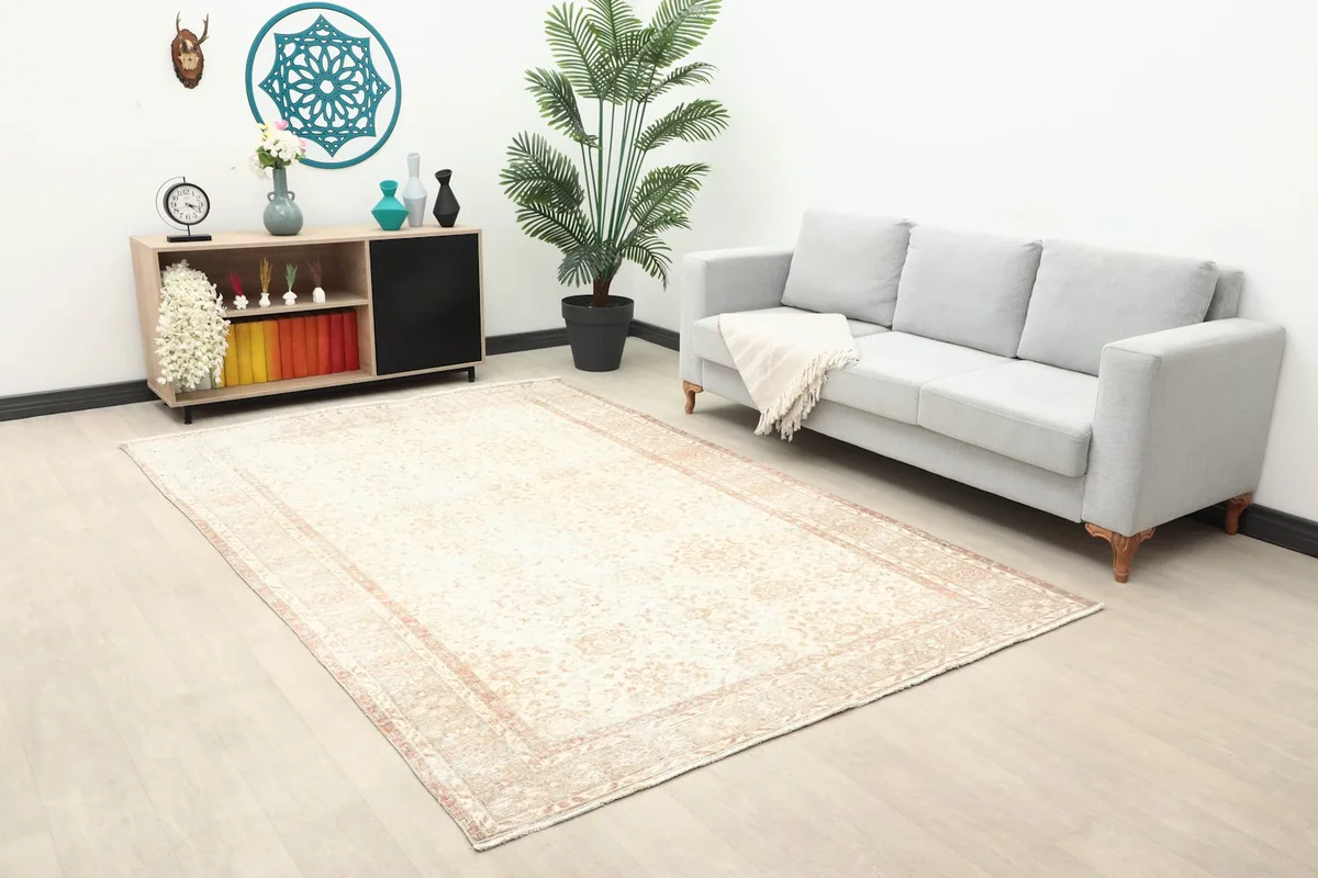 Cream and rose rug displayed in a room with modern furniture and decor