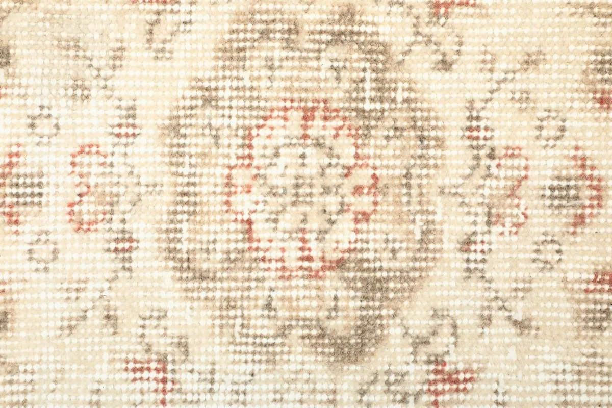Close-up of a central medallion-like motif showing the wool pile and color variations