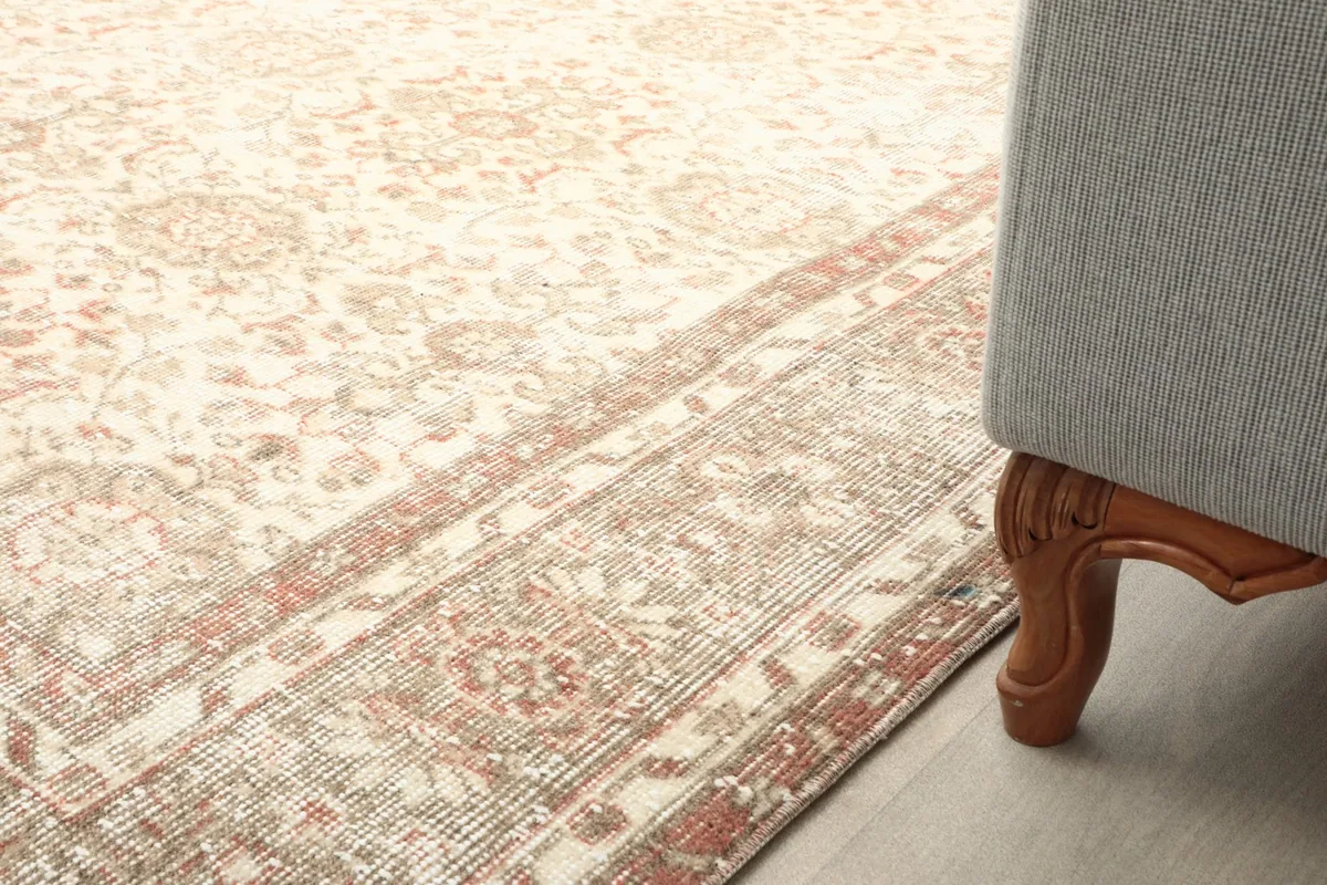 View of the rug's border next to a furniture leg, highlighting the design and low pile