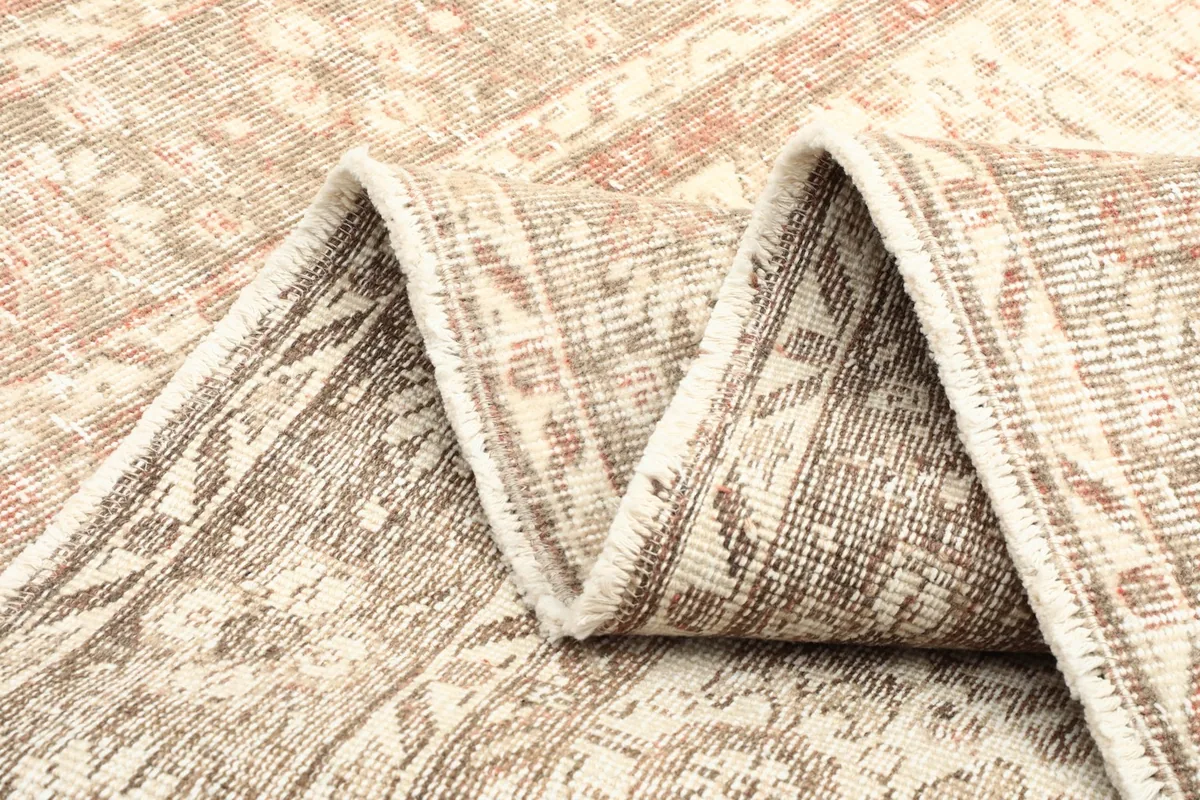 Multiple folds of the rug showing the intricate weave and reverse side