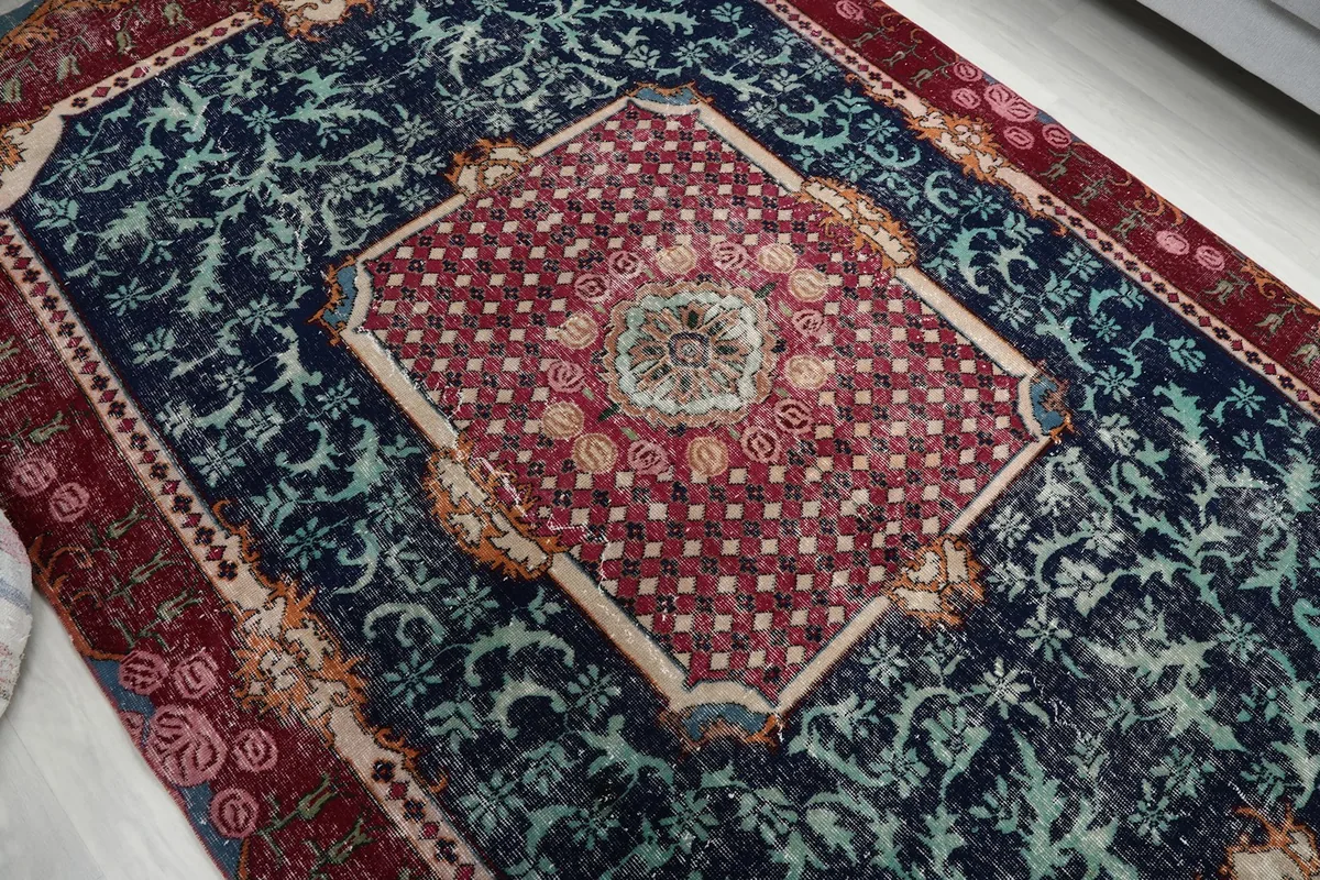 Overhead angle shot highlighting the central red medallion and navy floral patterns