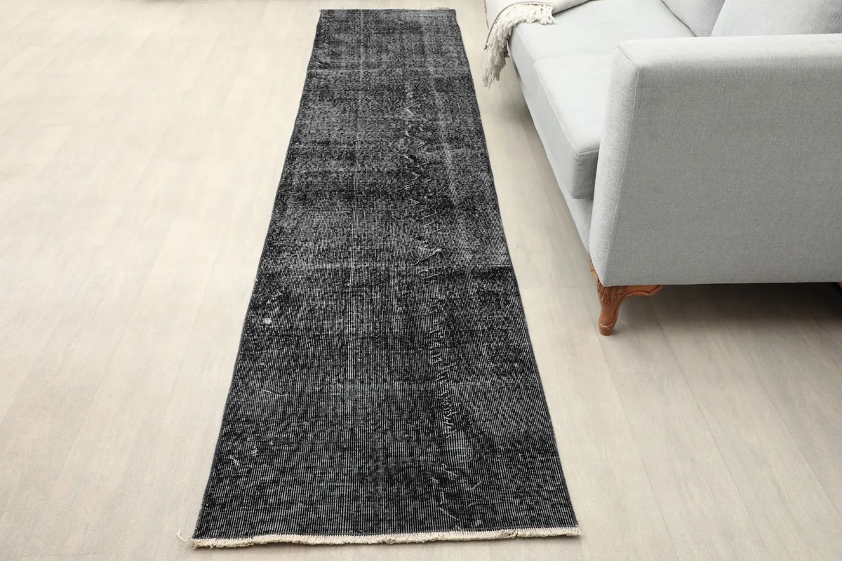 Charcoal runner placed in a modern living room setting next to a gray sofa