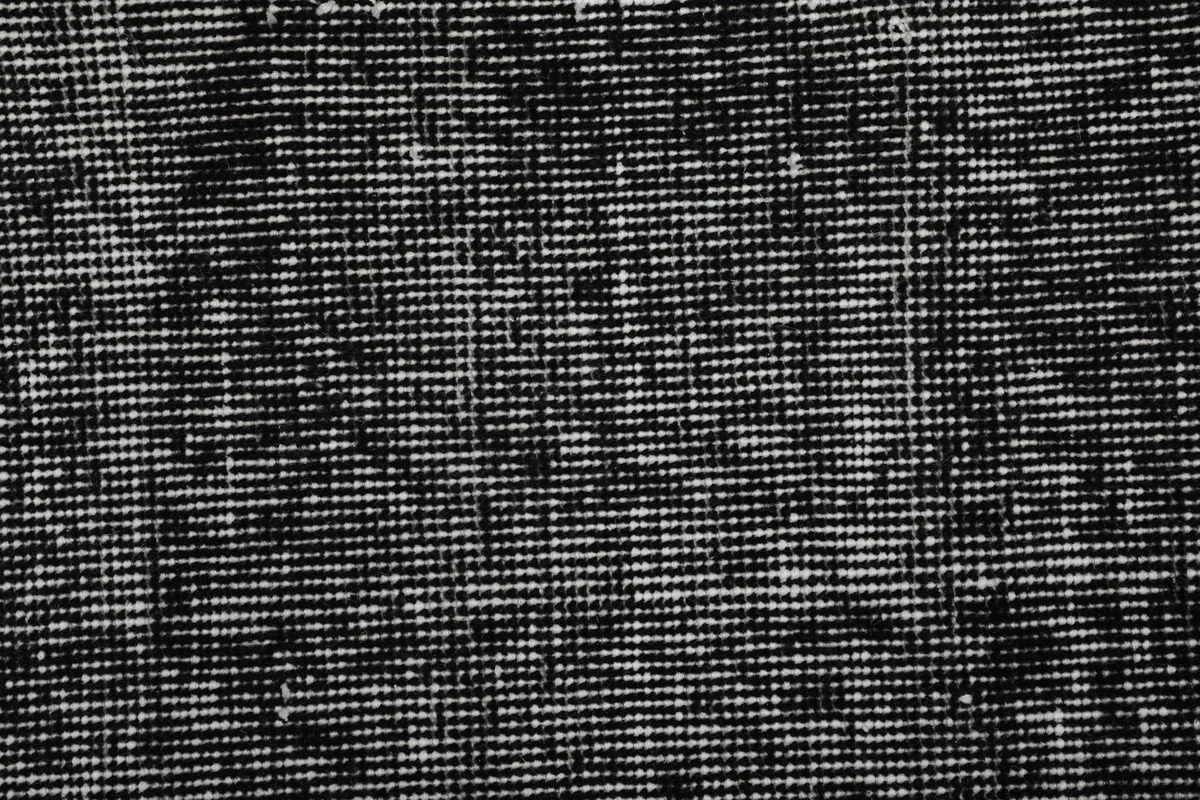 Detailed view of the hand-knotted weave and variations in the charcoal pile