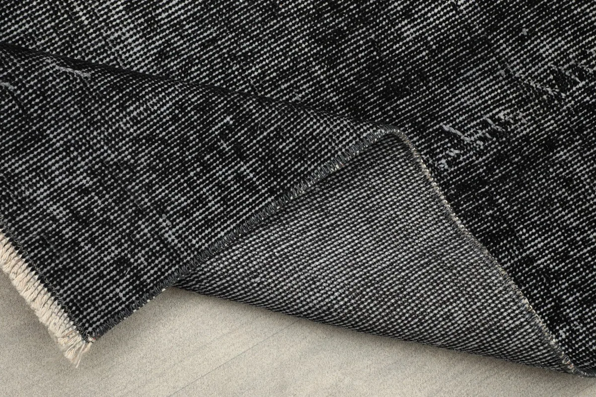 Folded corner of the runner revealing the cotton foundation and tight weave