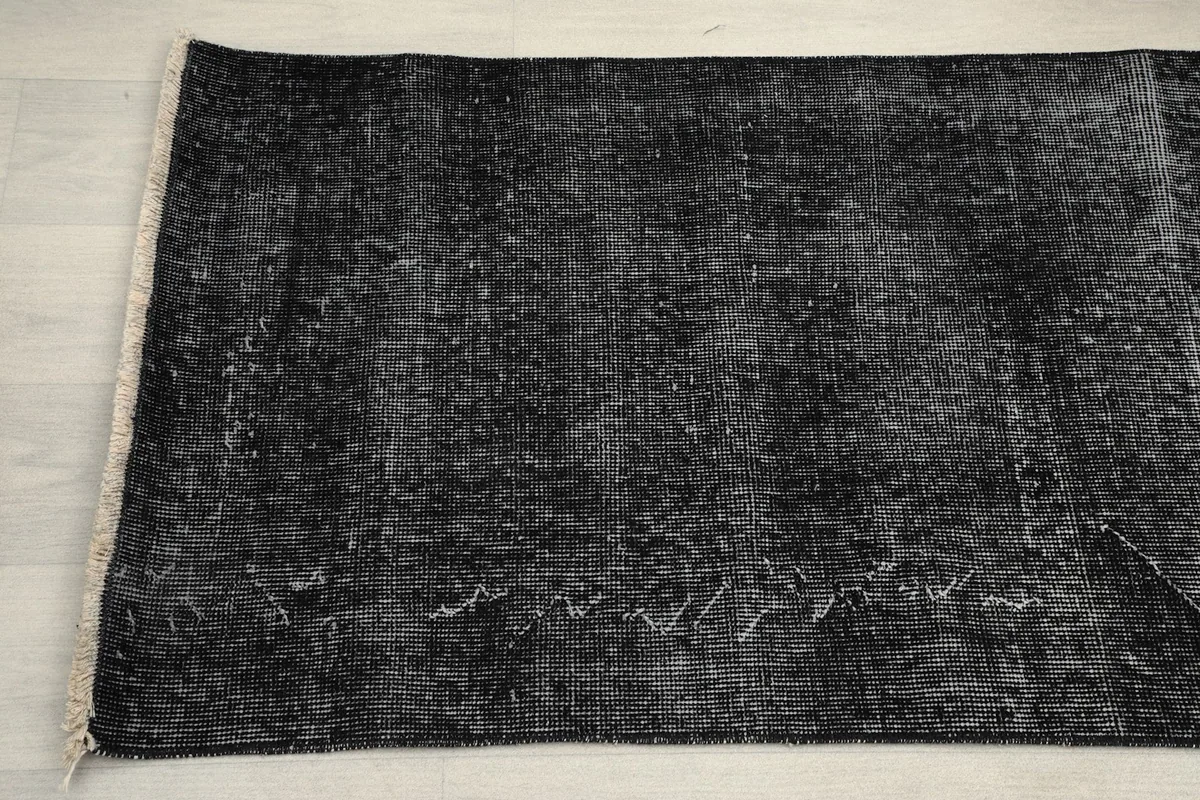 Detailed view showing the varied fading and subtle pattern remnants on the rug's surface