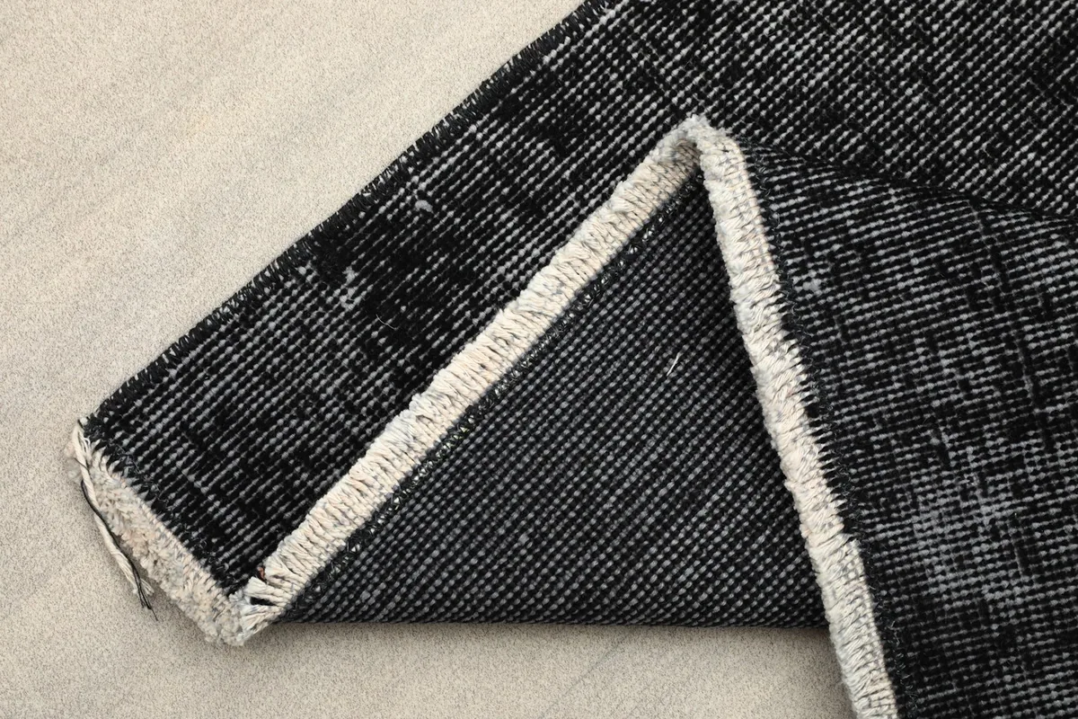 View of the rug's backside and cotton foundation, showing the hand-knotted construction