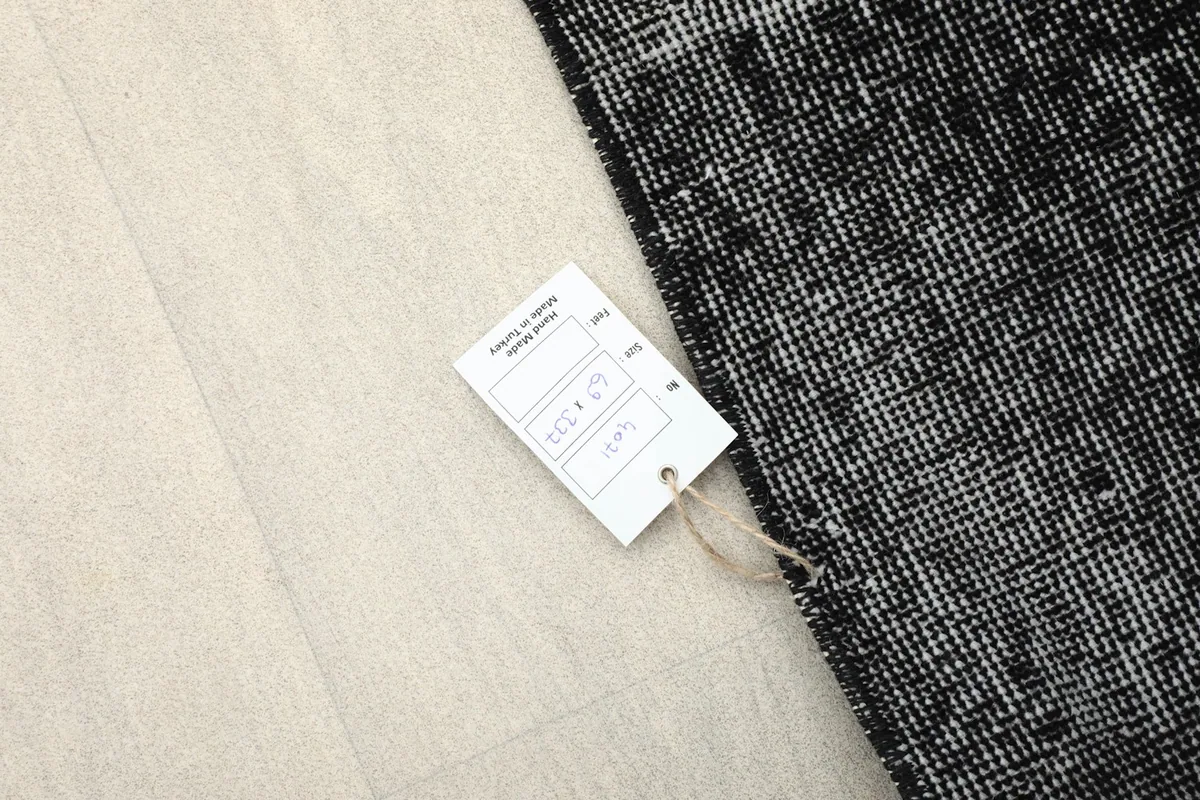 Product tag displaying rug information next to the distressed charcoal runner
