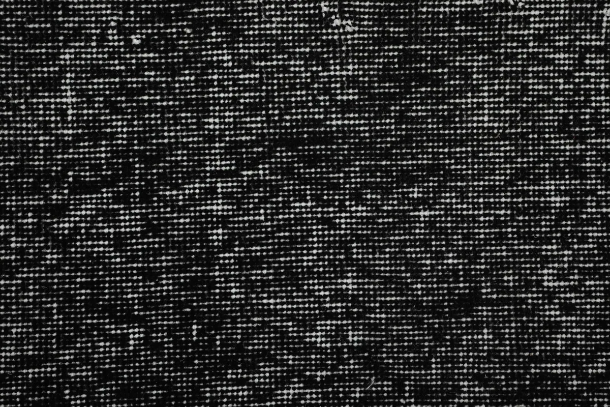 Tight detail shot of the black and gray wool pile, showing the hand-knotted texture