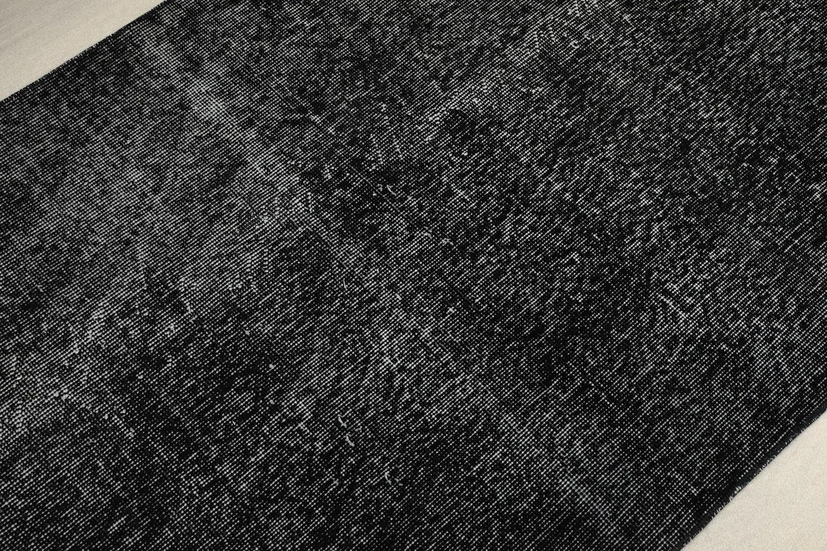 Angled close-up of the low pile and textured surface of the vintage black runner