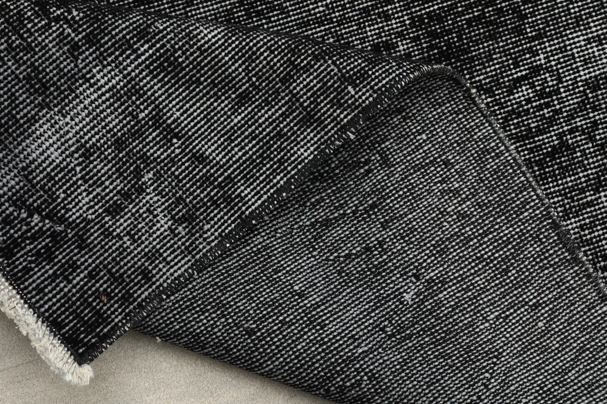 View of the back of the rug, showing the hand-knotted cotton foundation and wool pile