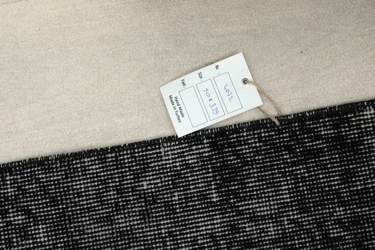 Close-up of the rug's edge with a tag showing its dimensions
