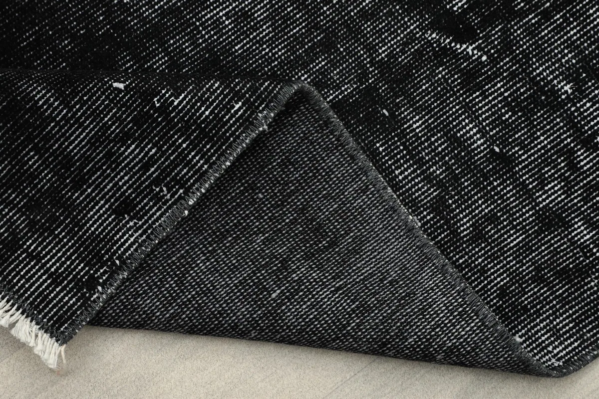 Folded corner of the rug displaying the tight knotting and wool pile