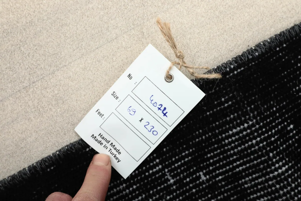 Label showing the 69 x 230 cm size and 'Hand Made in Turkey' on the rug