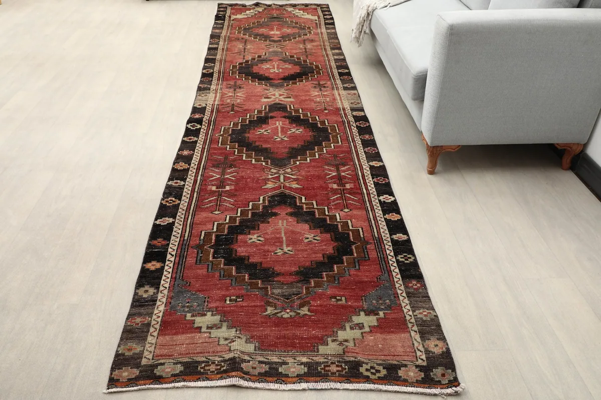 Vintage runner rug in a modern living space, showing its length and scale next to a sofa