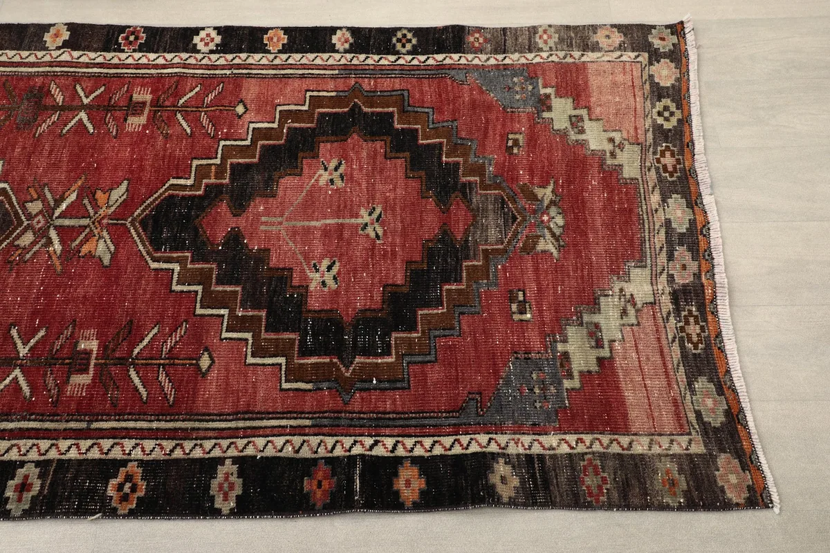 Close-up of a central black diamond motif on the red field, showing the intricate tribal details