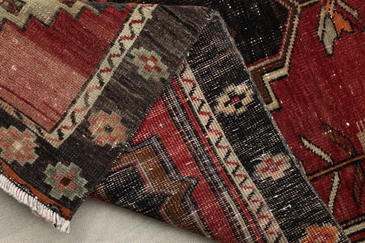 Partial view of the back of the rug, revealing the hand-knotted construction and fringe