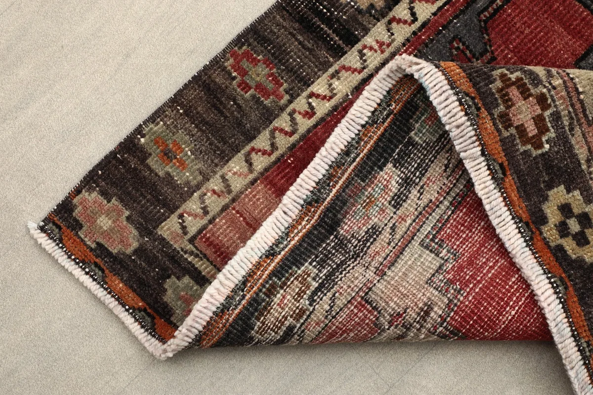 View of the rug folded to show the thickness of the wool pile and the cotton foundation