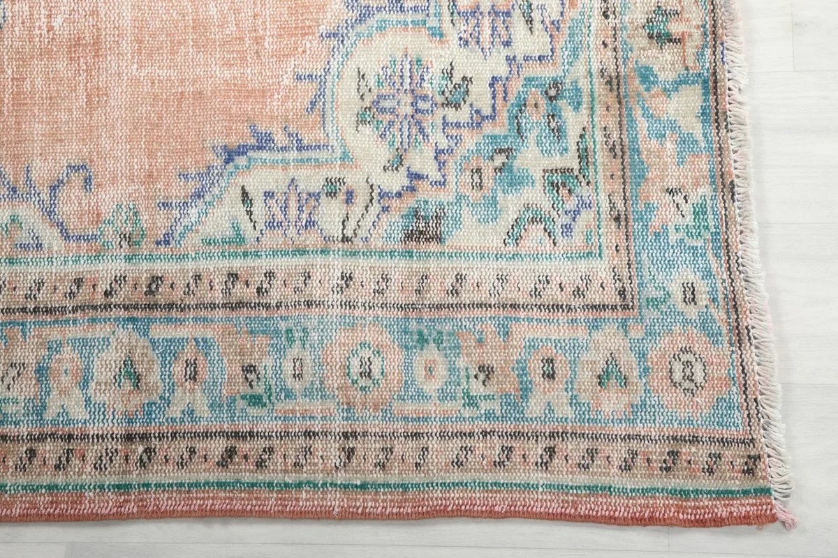 Detailed view of the blue and ivory border pattern and faded patina