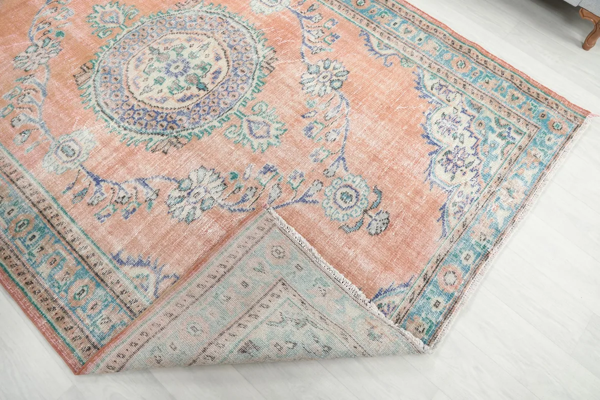 Corner of the rug folded back to show the cotton foundation and knotting