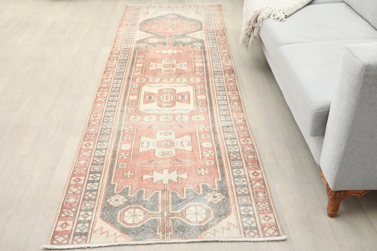 Vintage runner rug in a contemporary living space, showing its length next to a light gray sofa.