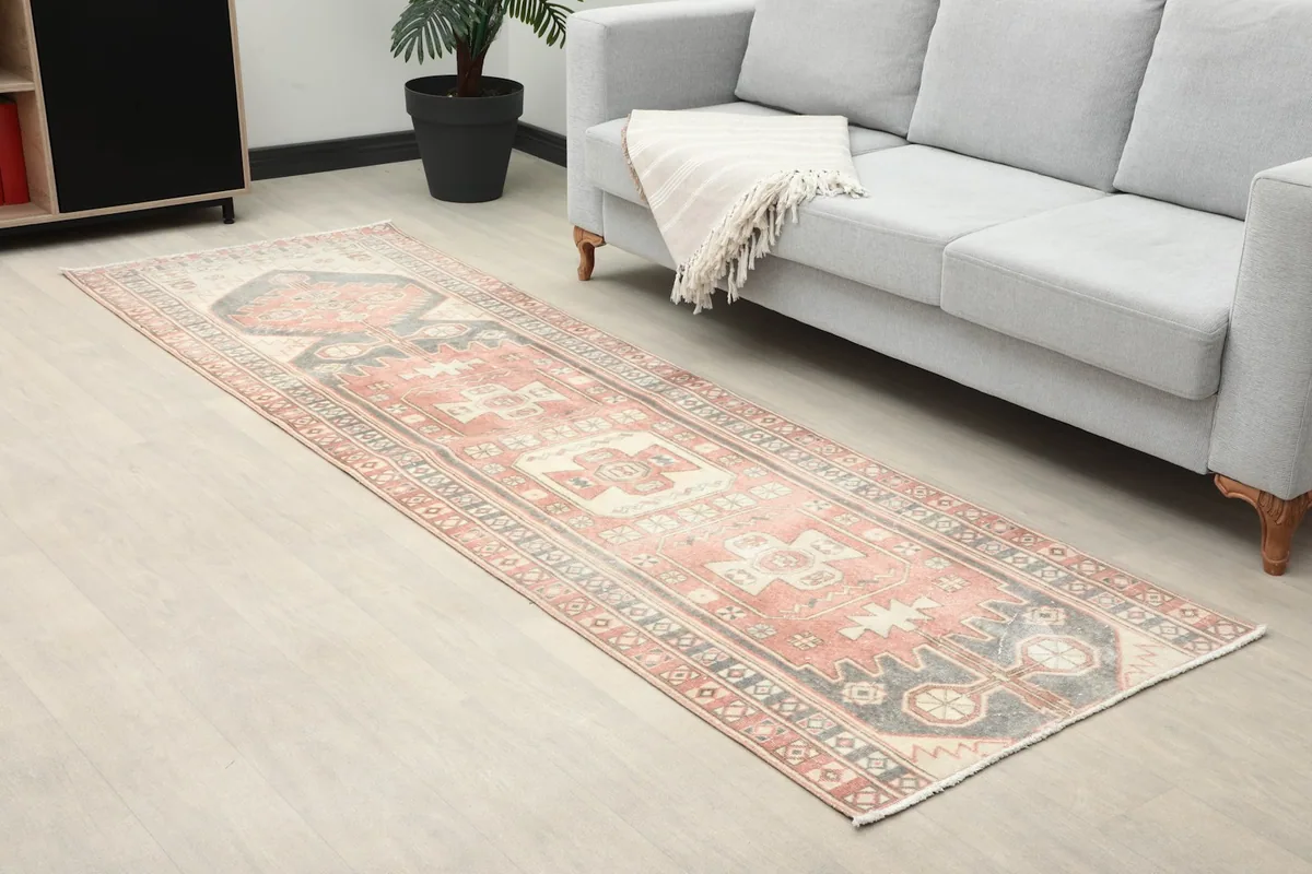 Angle view of the runner rug extending from a sofa, showing its fit in a living area.