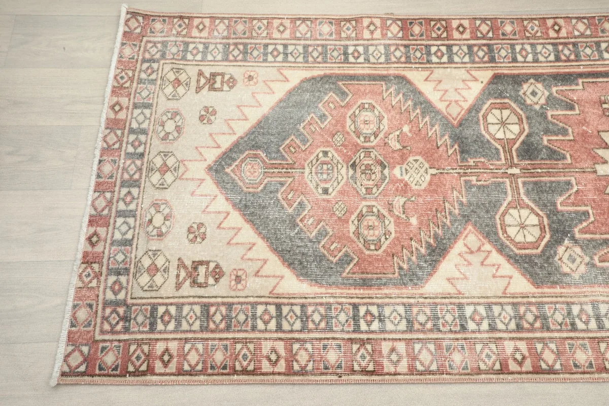 Detailed view of the rug's tribal design elements and border patterns from an angle.