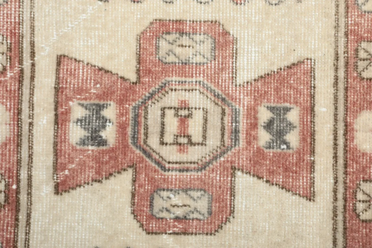 Macro detail of the hand-knotted pile and the intricate central motif with gray accents.