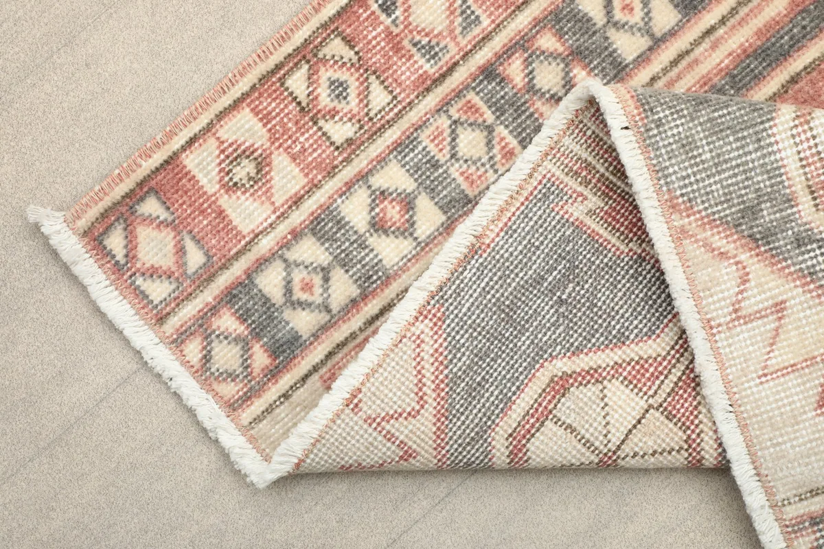 Folded section of the rug showing the low pile texture and the wool on cotton foundation.