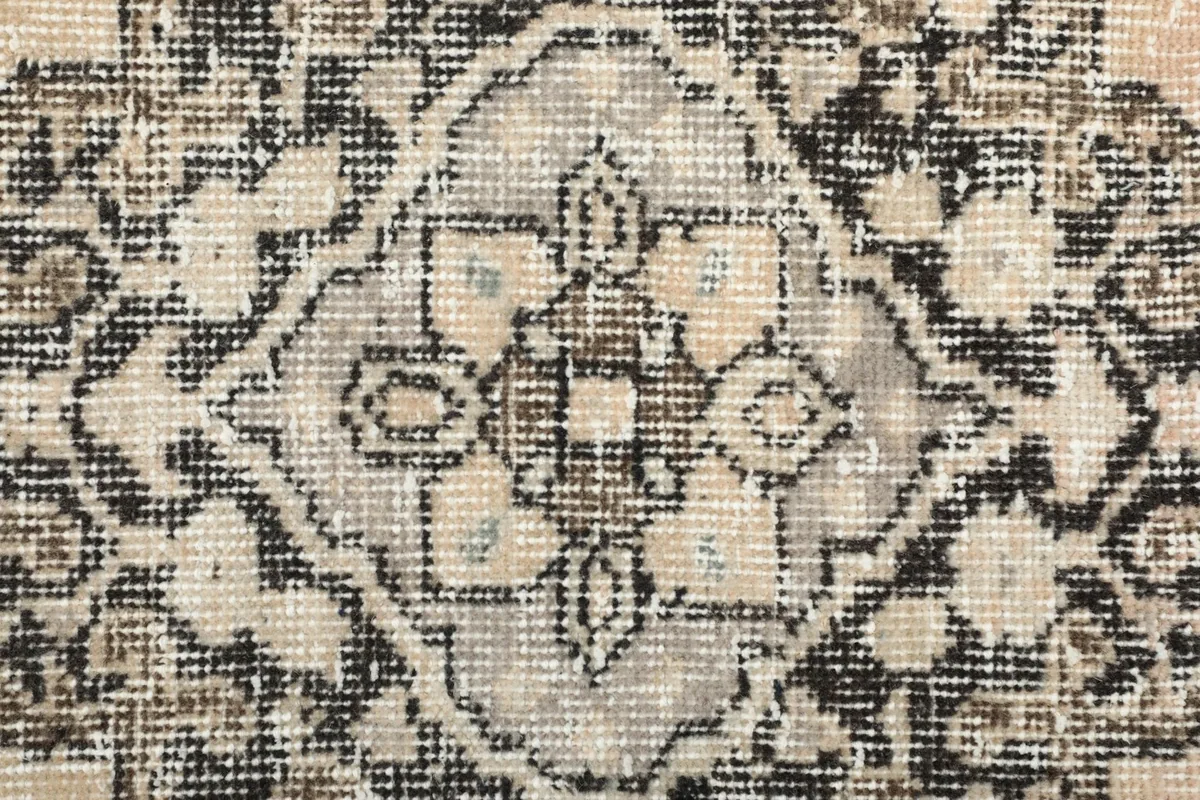 Extreme close-up showing the low wool pile and hand-knotted texture of the rug