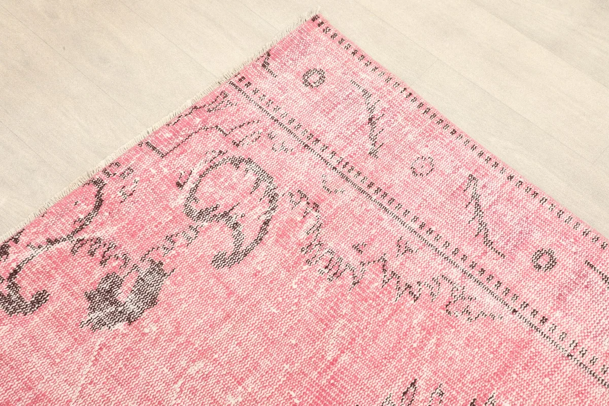 Detail of the corner and border pattern of the rose rug with charcoal accents