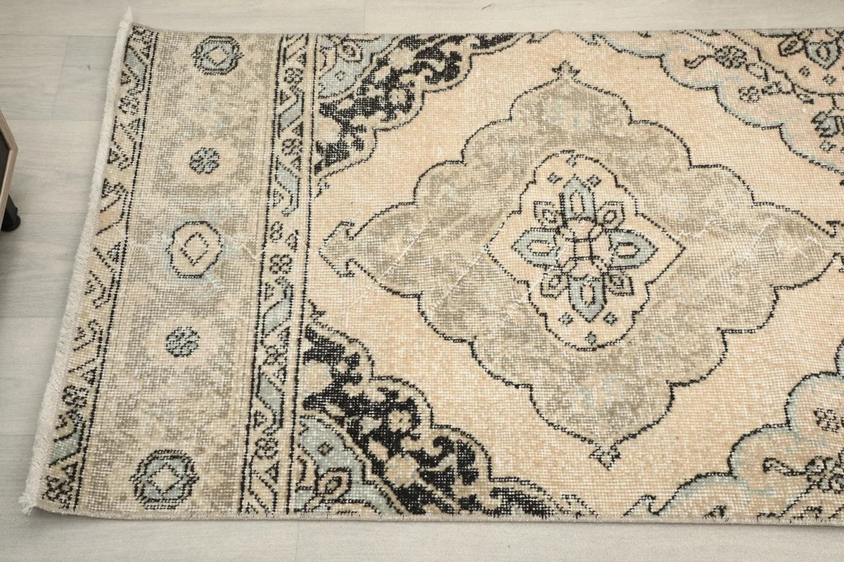 Detailed shot of the rug's patterned border and part of a medallion, showing color variations