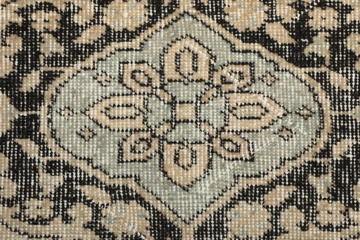 Macro view of the hand-knotted wool pile, showing the intricate details and low pile height