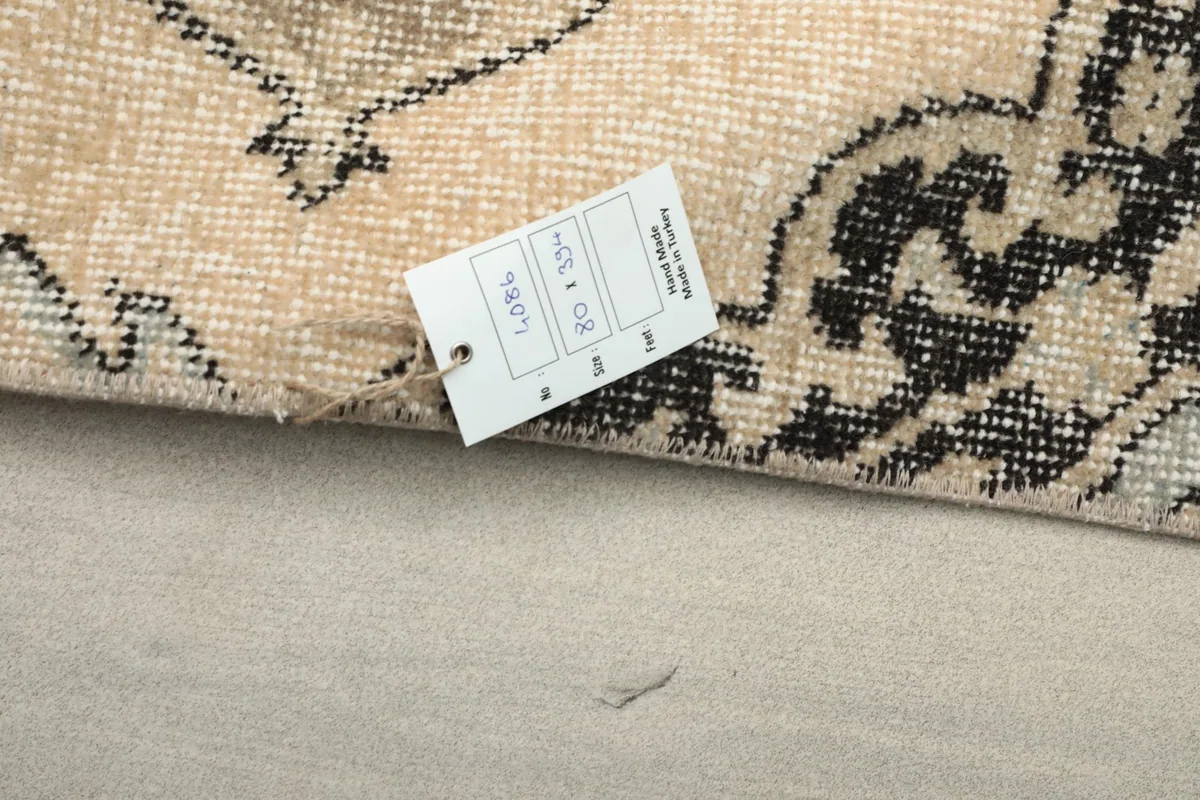 Close-up of the rug's label with size information (80 x 394 cm) and origin details