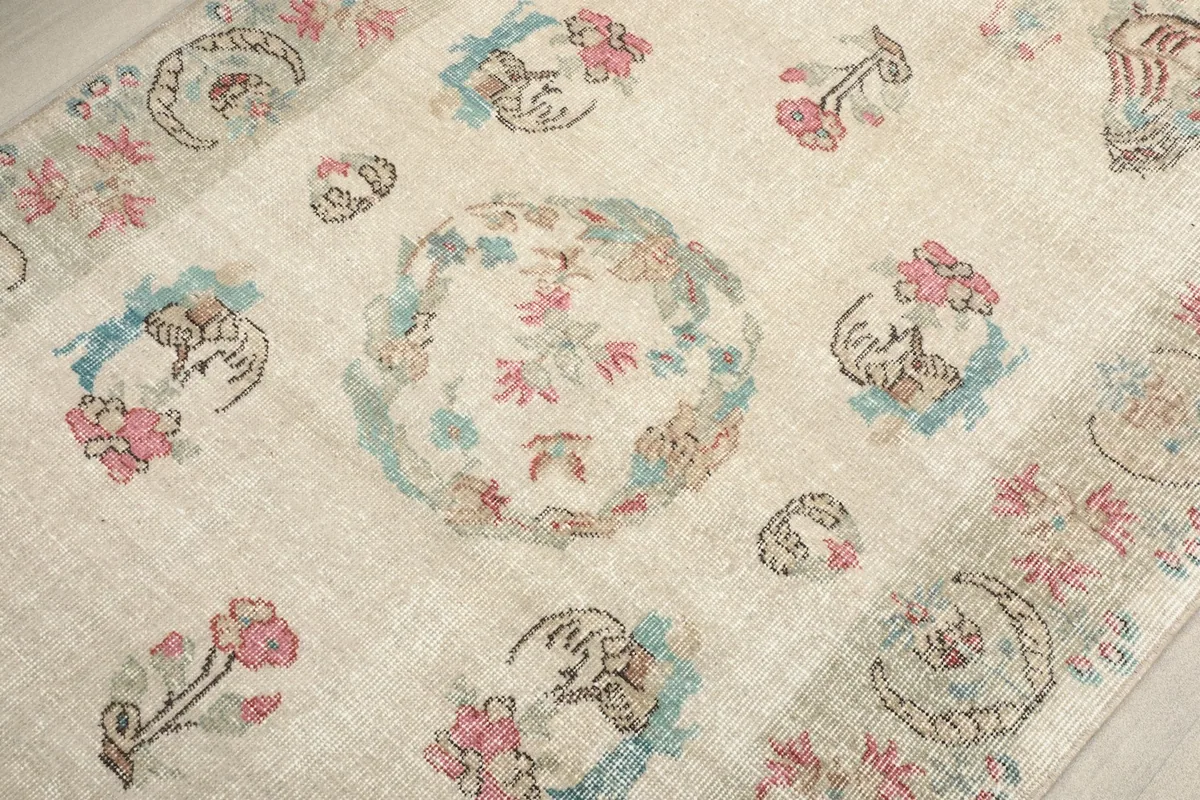 Detailed view of the central medallion and surrounding floral elements, revealing the hand-knotted texture.