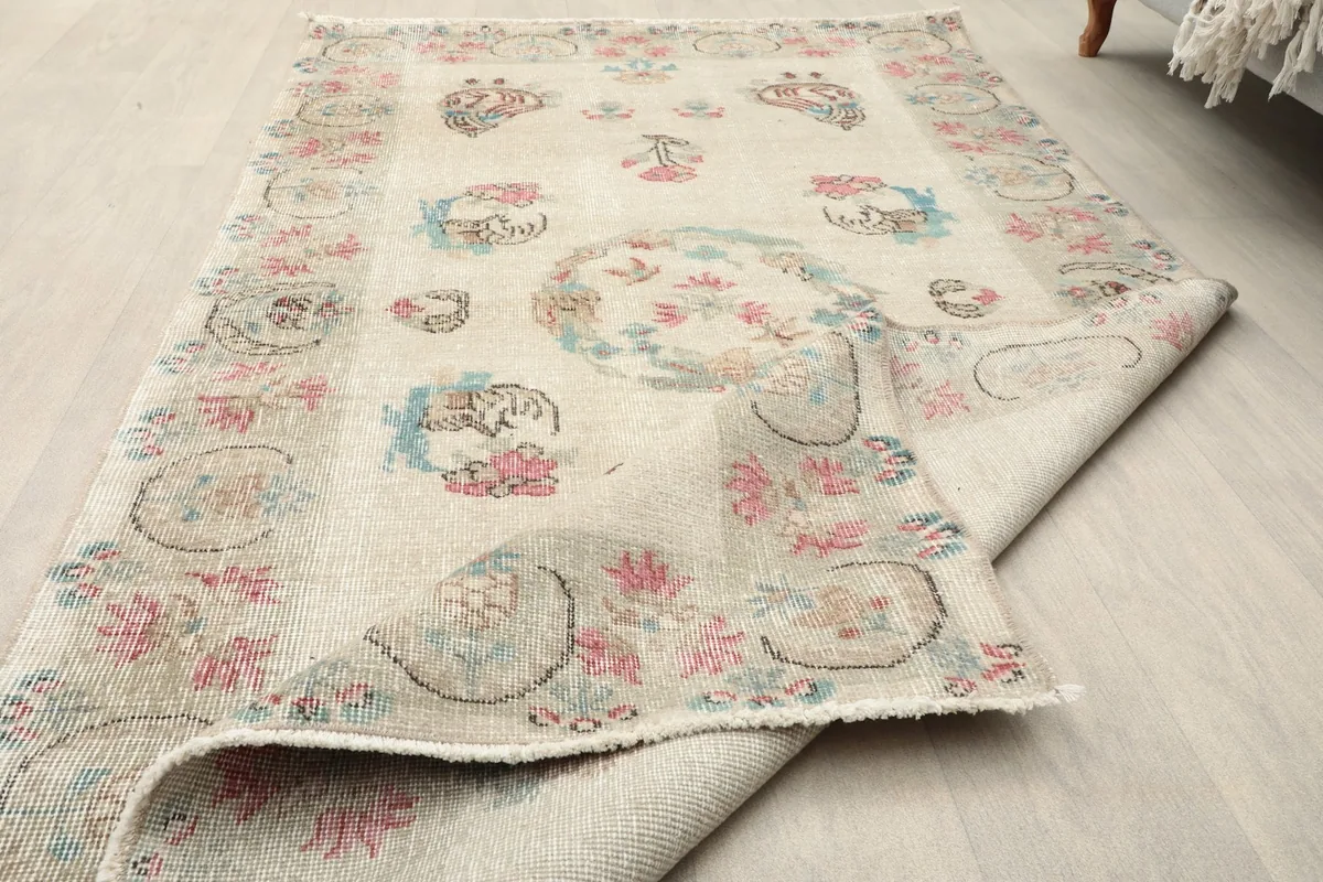 The rug partially folded on a light wood floor, illustrating its flexibility and the overall design.