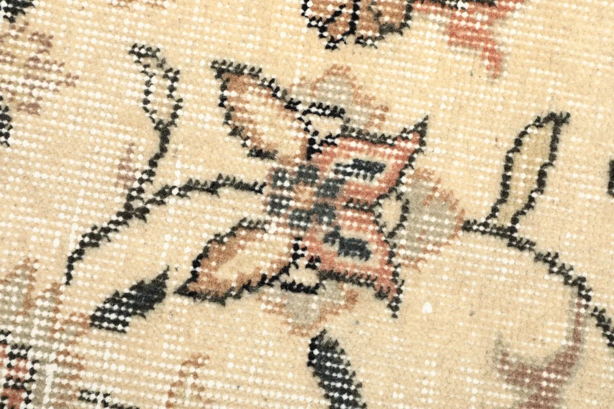 Close-up showing the low wool pile and hand-knotted floral motifs
