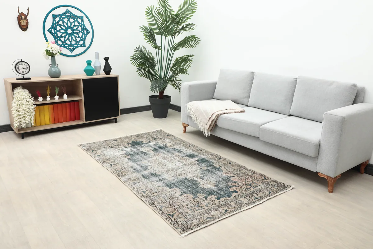Faded Gray Medallion Rug placed in a living room with a gray couch, providing scale.
