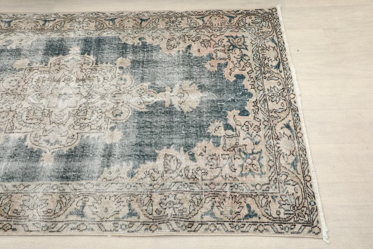 Close-up of the Faded Gray Medallion Rug's corner, showing faded beige and rose tones in the border.