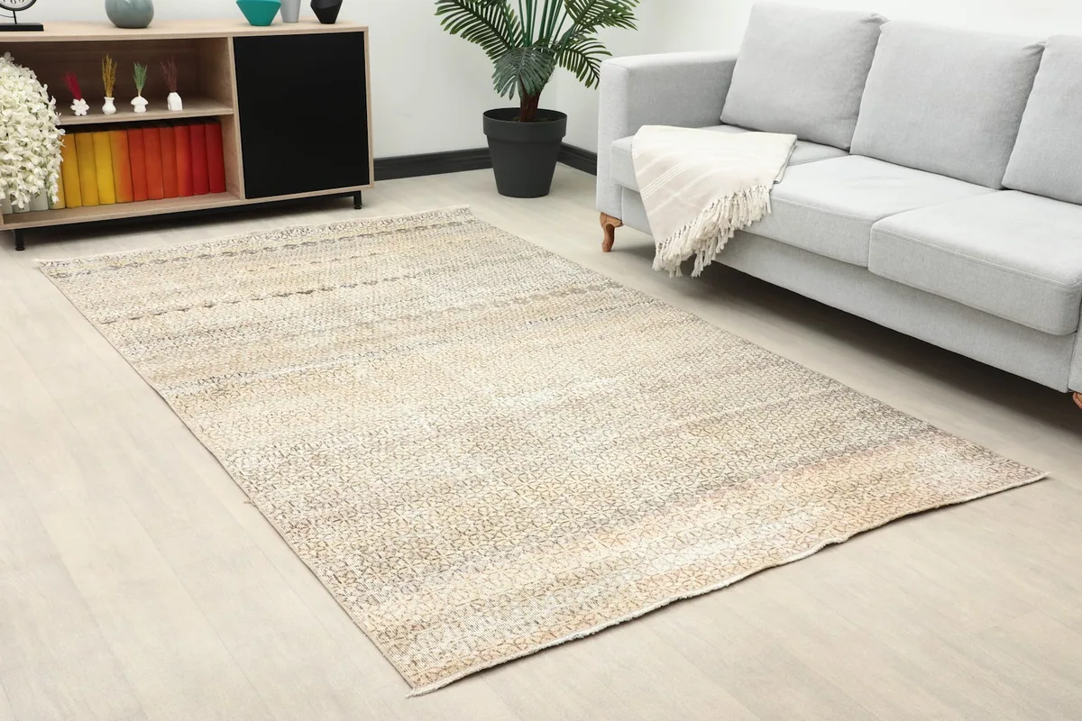 Close-up room view showing the beige and gray geometric rug complementing modern decor