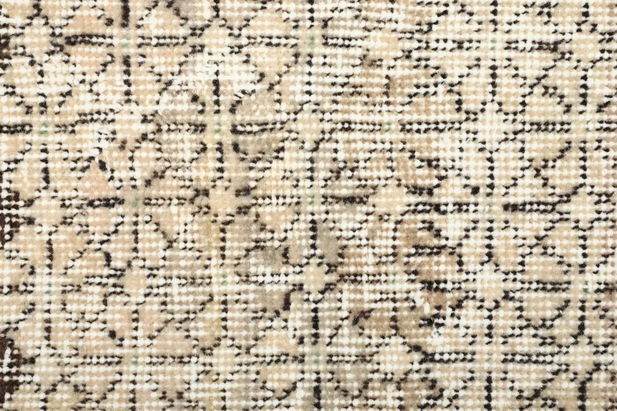 Macro detail of the beige and dark gray knotting, showing the weave structure