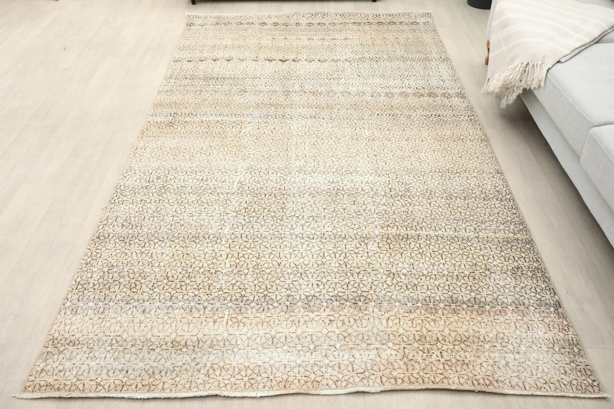 Overhead view of the beige and gray vintage rug laid out in a room