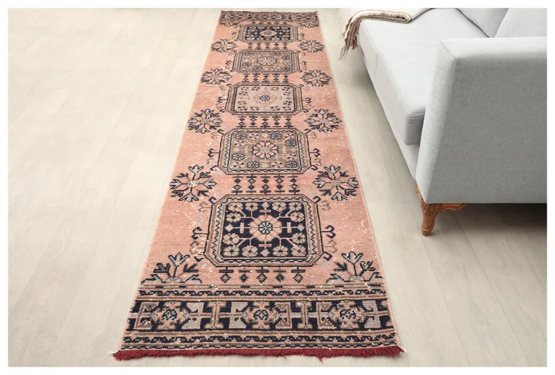 Full top view of a 2'7" x 11'0" rose and navy geometric vintage Anatolian runner rug on a white background.